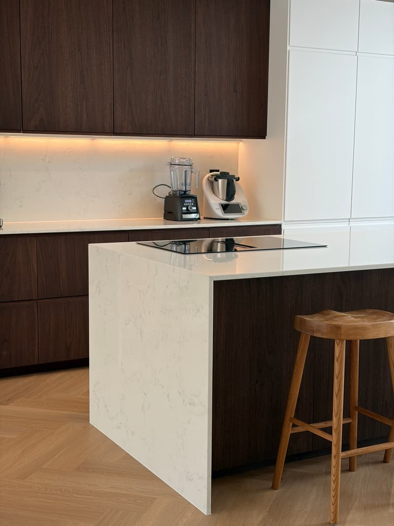 Moderne IKEA keuken met donker houten kasten, wit marmeren werkblad en eetbar